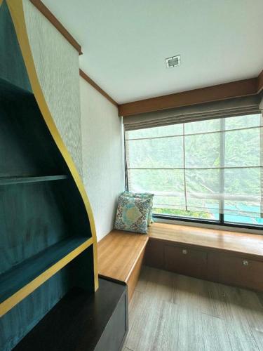 a room with a window with a bench and a chair at Phi Phi Nice Beach Hotel Hip in Phi Phi Don