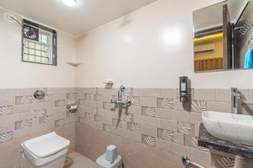 a bathroom with a toilet and a sink at Aaru Retreat - Lonavala in Khamshet