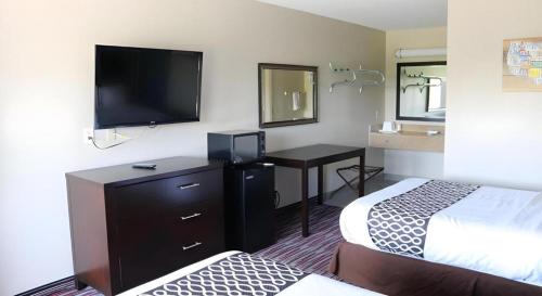 a hotel room with two beds and a flat screen tv at Econo Lodge Inn & Suites in Enid