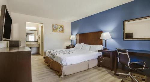a hotel room with a large bed and a desk at Econo Lodge Inn & Suites in Enid
