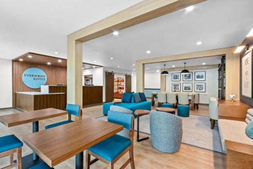 a lobby with tables and chairs and a dining area at Everhome Suites Chandler Phoenix Fashion Center in Chandler