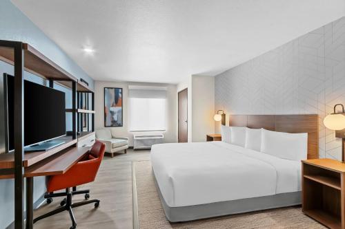 a hotel room with a bed and a desk with a computer at Everhome Suites Chandler Phoenix Fashion Center in Chandler