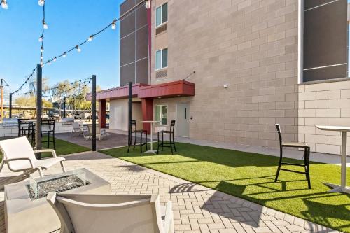 a patio with chairs and tables and grass at Everhome Suites Chandler Phoenix Fashion Center in Chandler