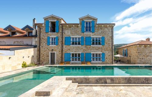 eine Villa mit einem Pool vor einem Gebäude in der Unterkunft 1 Bedroom Amazing Home In Mundanije in Mundanije