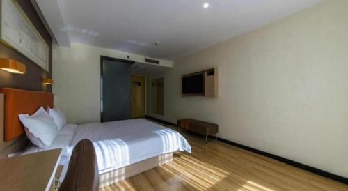 a hotel room with a bed and a television at 7 Days Premium Tangshan Railway Station Jiaotong University in Tangshan