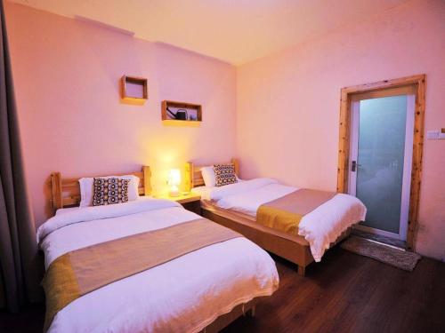a hotel room with two beds and a window at Spring Flowers Blossoming Hotel in Yangshuo