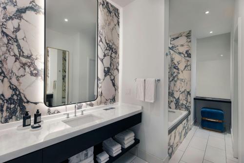 a bathroom with a sink and a mirror and a tub at W Austin in Austin