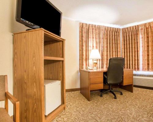 a hotel room with a desk and a chair and a television at Econo Lodge Inn & Suites in Stevens Point