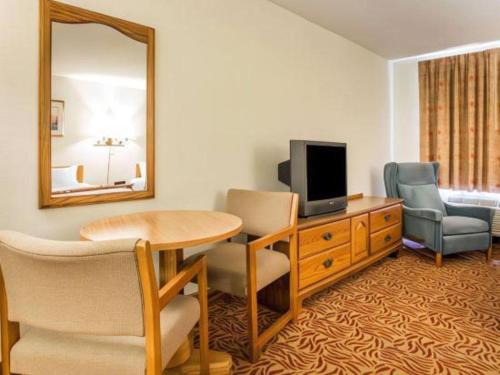 a room with a table and a television and a mirror at Econo Lodge Inn & Suites in Stevens Point