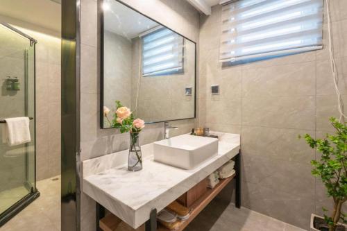 ein Badezimmer mit Waschbecken und Spiegel in der Unterkunft GreenTree Inn Jinan Quancheng Hotel in Jinan
