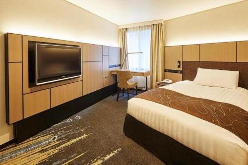 a hotel room with a bed and a flat screen tv at Akasaka Excel Hotel Tokyu in Tokyo