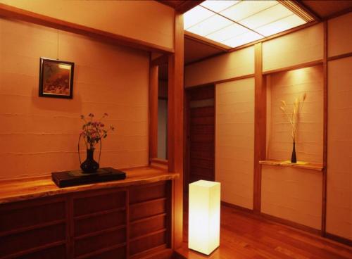 a room with a vase of flowers on a table at Kannawa Onsen Hotel Sansuikan in Beppu