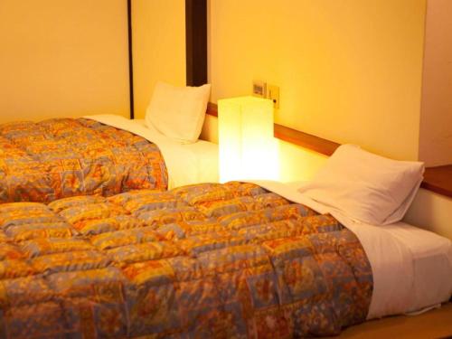 two beds sitting next to each other in a hotel room at Kannawa Onsen Hotel Sansuikan in Beppu