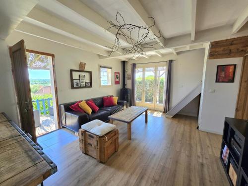 un salon avec un canapé et une table dans l'établissement O balcon de Thau : Un véritable havre de paix, une maison avec vue dégagée, 2 chambres et jardin., à Mèze