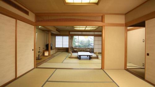 a hallway with a room with a table in it at Hotel Tokoen in Yonago