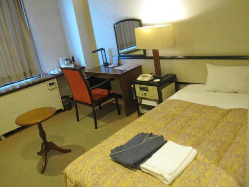 a hotel room with a bed and a desk at Ako Royal Hotel in Himeji