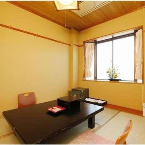 a dining room with a black table and a window at Shirako New Seaside Hotel in Shirako
