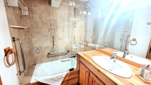 une salle de bain avec un lavabo et une douche en verre dans l'établissement Résidence Week End - Appartement spacieux et lumineux, en plein centre MAE-2591, aux Gets