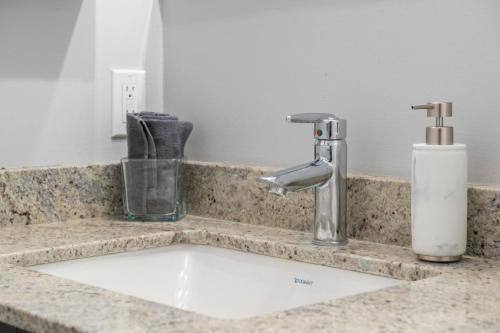a bathroom counter with a sink and a faucet at Downtown Chic Retreat | Elegant + Free Parking in Calgary