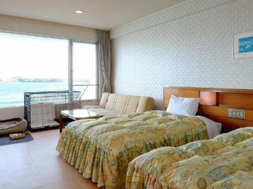a hotel room with two beds and a couch at Hamanako Lake Side Plaza in Hamamatsu