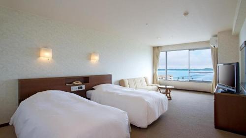 a hotel room with two beds and a flat screen tv at Hamanako Lake Side Plaza in Hamamatsu