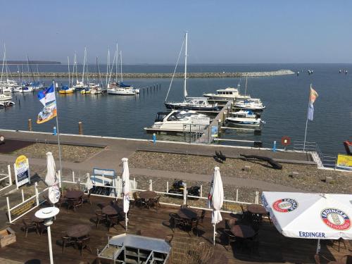a marina with tables and chairs and boats in the water at Sur la Mer - Pension Garni in Barth