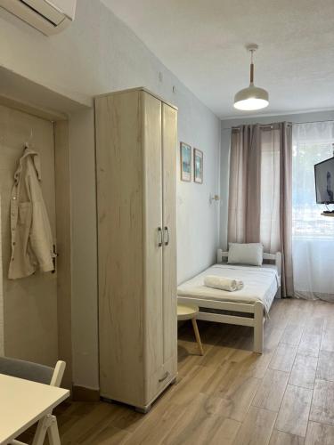 a small room with a bed and a cabinet at Apartments Astoria HN in Herceg-Novi
