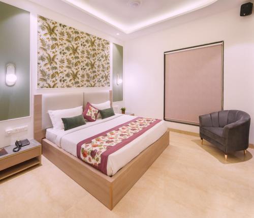 a bedroom with a large bed and a chair at Hotel Star Suites By Star Group in New Delhi
