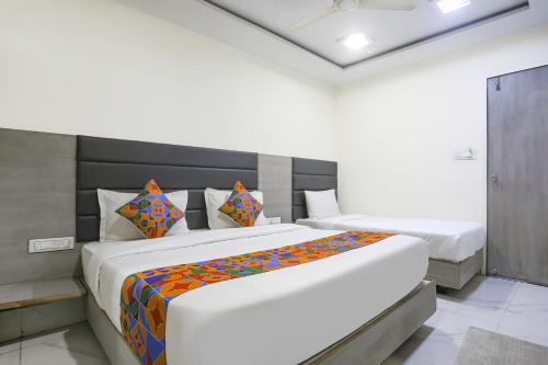 a bedroom with two beds in a room at FabHotel SS - Opp Vishwakarma Engineering College in Ahmedabad