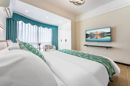 a bedroom with a large white bed and a window at 漫点 Moodlink Hotel at Taikoo Hui, Sports Center in Guangzhou
