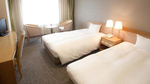 a hotel room with two beds and a television at Ako Park Hotel in Ako