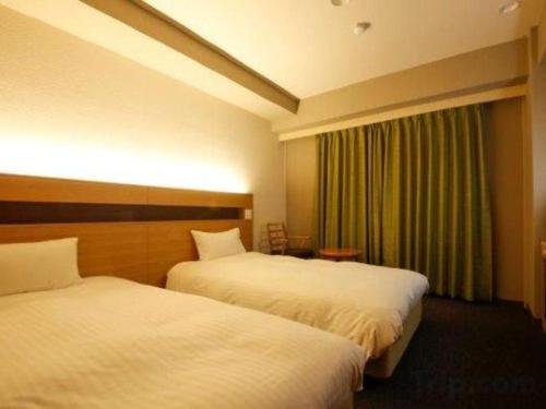 a hotel room with two beds and a window at Ako Park Hotel in Ako