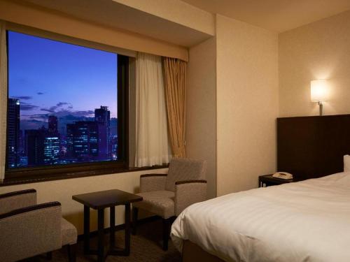 a hotel room with a bed and a window at Osaka Dai-ichi Hotel in Osaka
