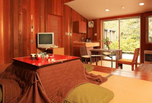 a living room with a bed and a television at Ukawa Onsen Yoshino no sato in Kyotango