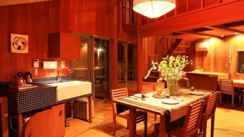 a kitchen and dining room with a table and a sink at Ukawa Onsen Yoshino no sato in Kyotango