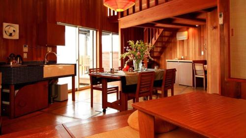 a kitchen and dining room with a table and chairs at Ukawa Onsen Yoshino no sato in Kyotango