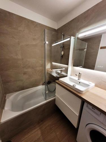 une salle de bain avec une baignoire, un lavabo et une douche dans l'établissement Résidence Helios - Bel appartement rénové, au calme et proche du centre MAE-1251, aux Gets