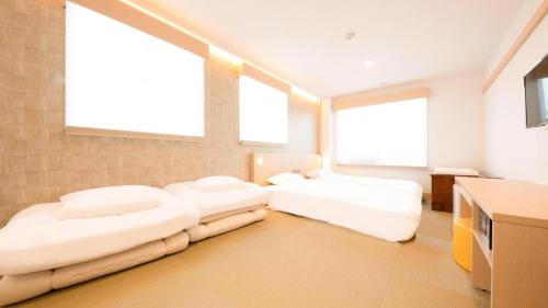 two beds in a large room with two windows at NAMBA EBISU HOTEL in Osaka