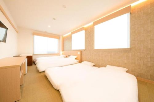 three beds in a room with three windows at NAMBA EBISU HOTEL in Osaka
