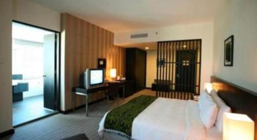 a hotel room with a bed and a television at RH Hotel Sibu in Sibu