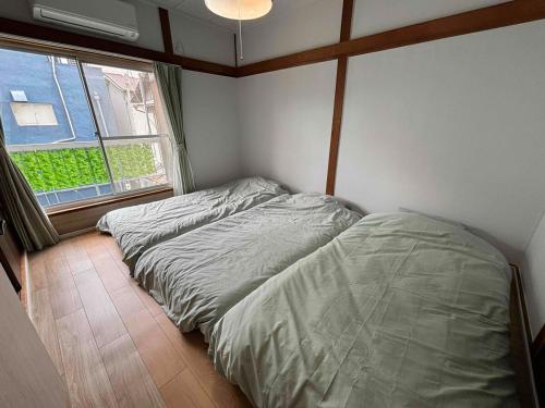 a small bedroom with a bed and a window at I Love SHIN-OSAKA in Osaka