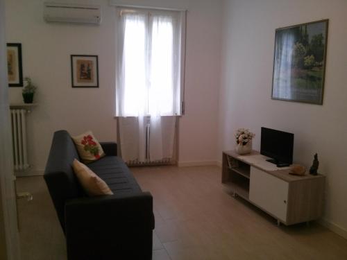 a living room with a couch and a television at Il Nido del Cigno in Sirmione