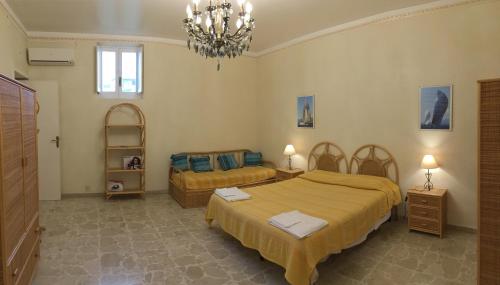 a bedroom with two beds and a chandelier at Case Vacanze Arcobaleno in Lipari