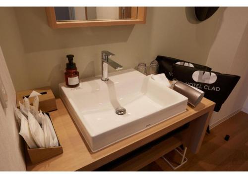 a bathroom sink with a bottle of soap on it at HOTEL CLAD in Fuji