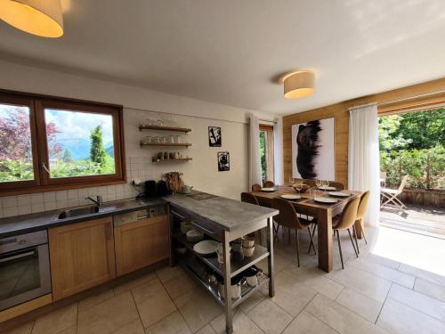 une cuisine avec une table et une salle à manger dans l'établissement Résidence Le ChampÉ - Grand appartement de plain-pied avec terrasse MAE-3421, aux Gets