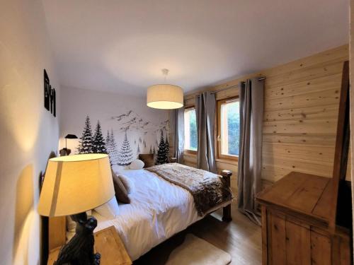 une chambre avec un lit, une lampe et une fenêtre dans l'établissement Résidence Le ChampÉ - Grand appartement de plain-pied avec terrasse MAE-3421, aux Gets