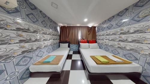 deux lits dans une petite pièce avec un mur dans l'établissement ARK HOTEL BATU CAVES, à Batu Caves