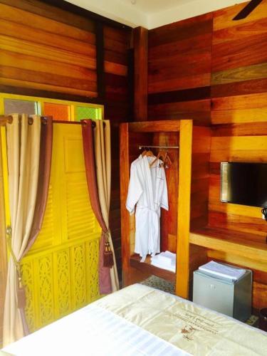 a bedroom with a bed and a room with wooden walls at Kampong Pinang Sebatang Melaka in Melaka