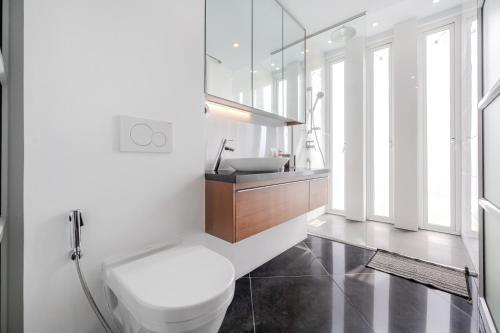 a bathroom with a white toilet and a sink at Pure Sunset Beach - Ocean View Room, Pattaya in Na Jomtien