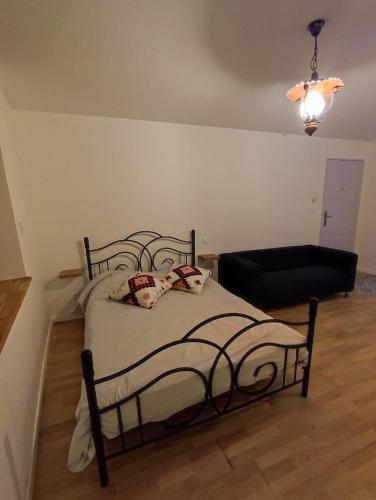a bedroom with a bed and a black couch at Studio calme à deux pas du lac de Nantua in Nantua